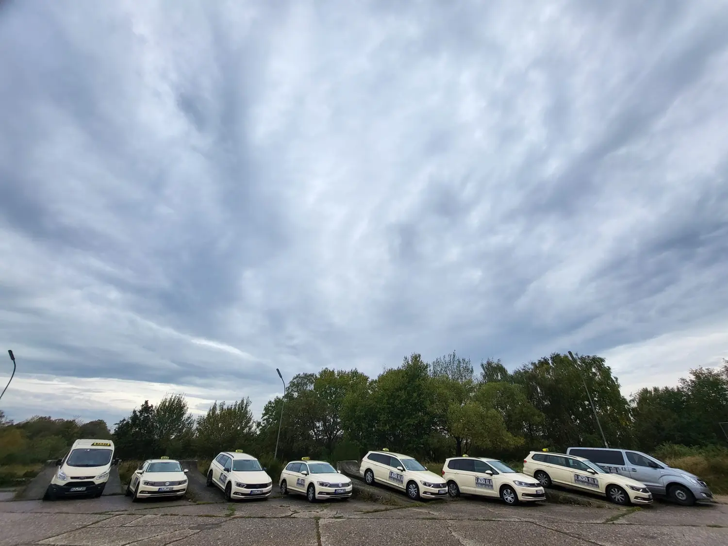 BonChance & TaxiTopTeam GmbH - Transportdienste - Eine Flotte weißer und hellfarbiger Volkswagen-Taxis.